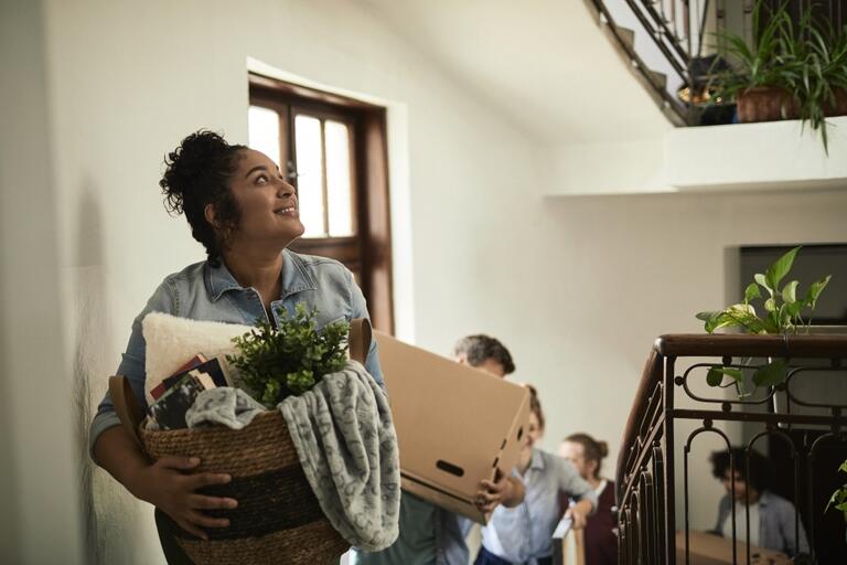 woman with boxes moving into a space.