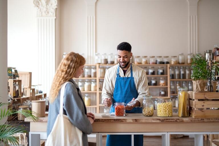 local shop with a woman shopping and a man helping her at the counter.