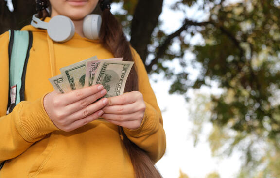 teen in hoodie with cash